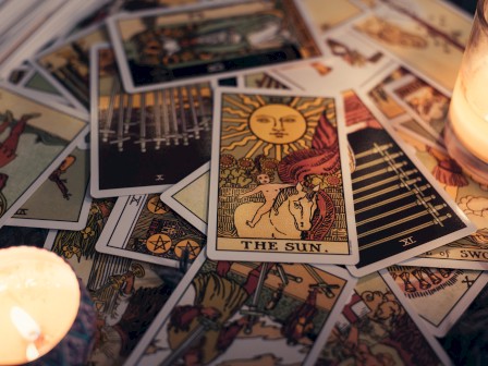 A collection of tarot cards is spread out on a surface, with 