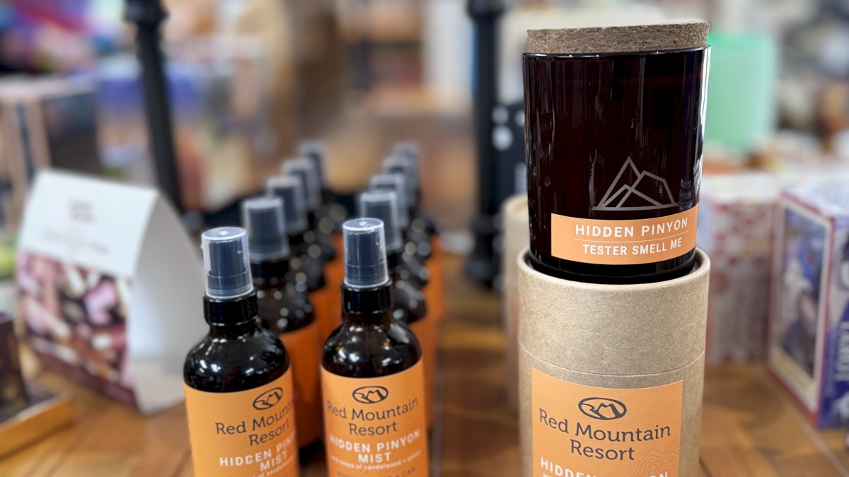 The image shows a display of products from Red Mountain Resort, including bottles of spray and two stacked jars labeled 